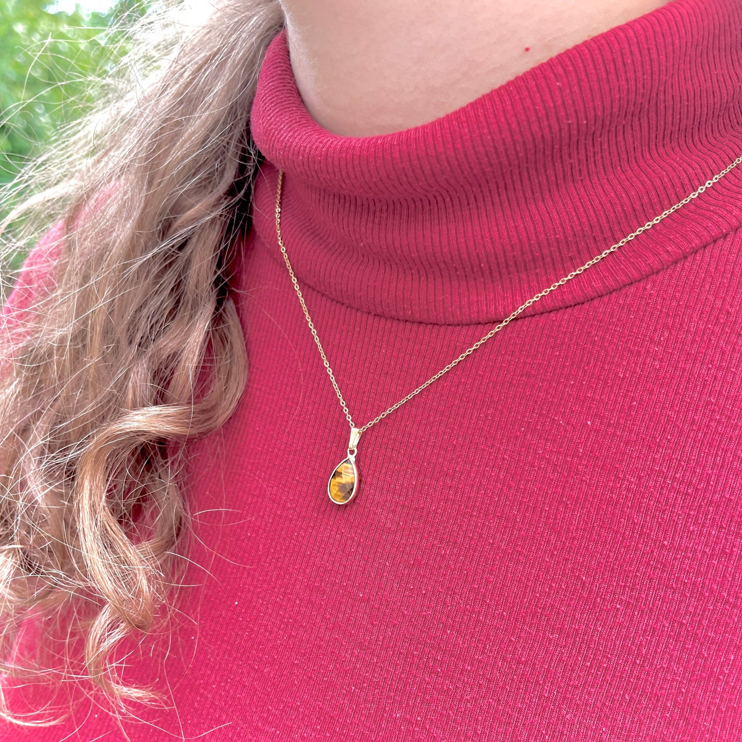 Collier pendentif oeil-de-tigre doré portée sur une femme