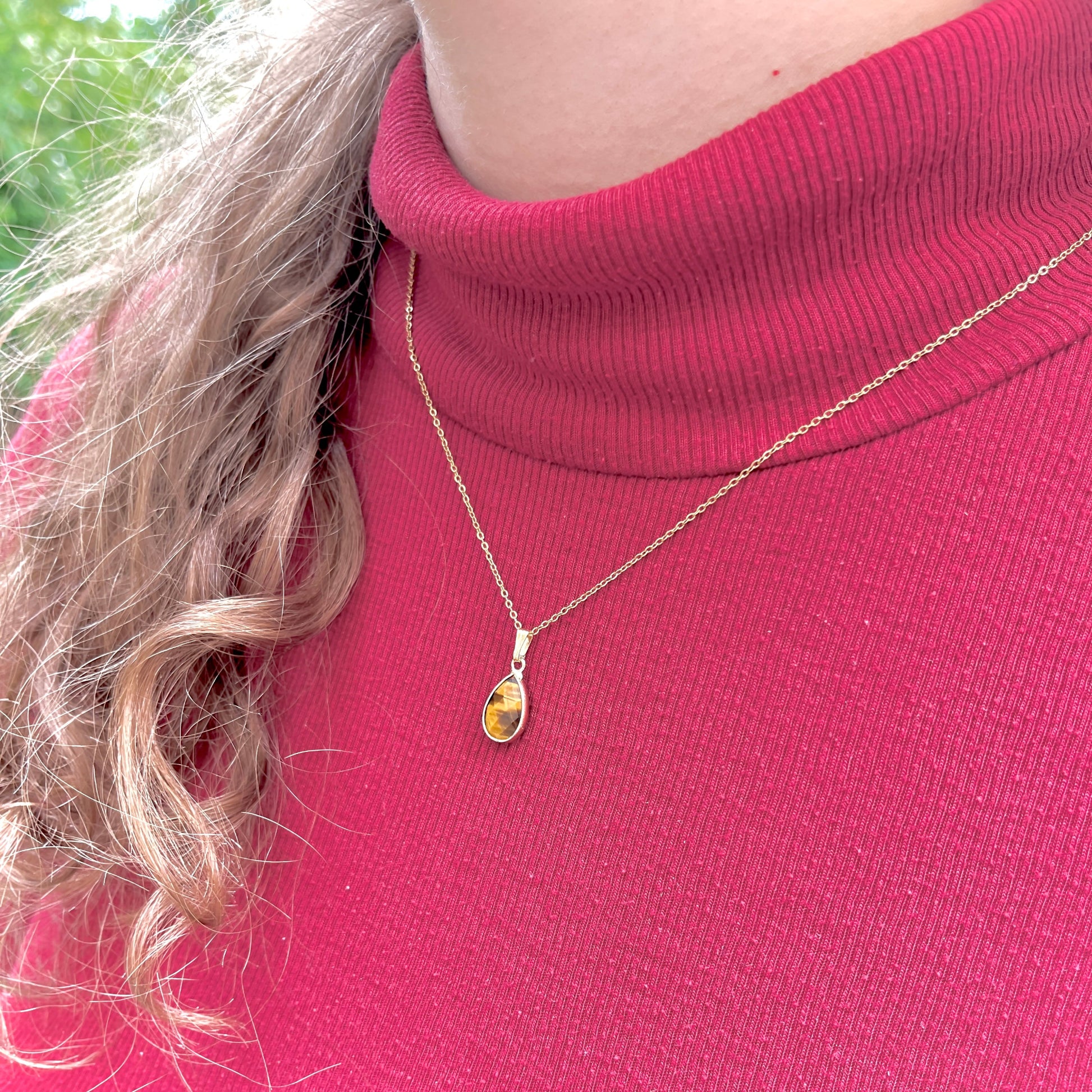 Collier pendentif oeil-de-tigre doré portée sur une femme